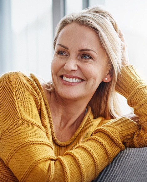 Woman smiling while relaxing on couch
